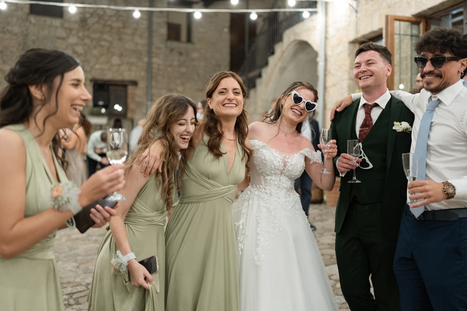 The couple and friends laughing with champagne