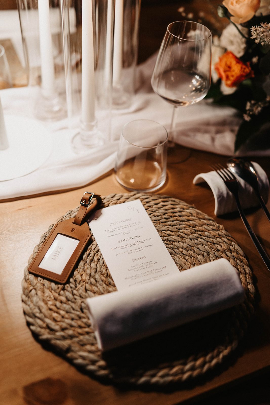 A place setting with a leather luggage-tag name card and the C/J menu