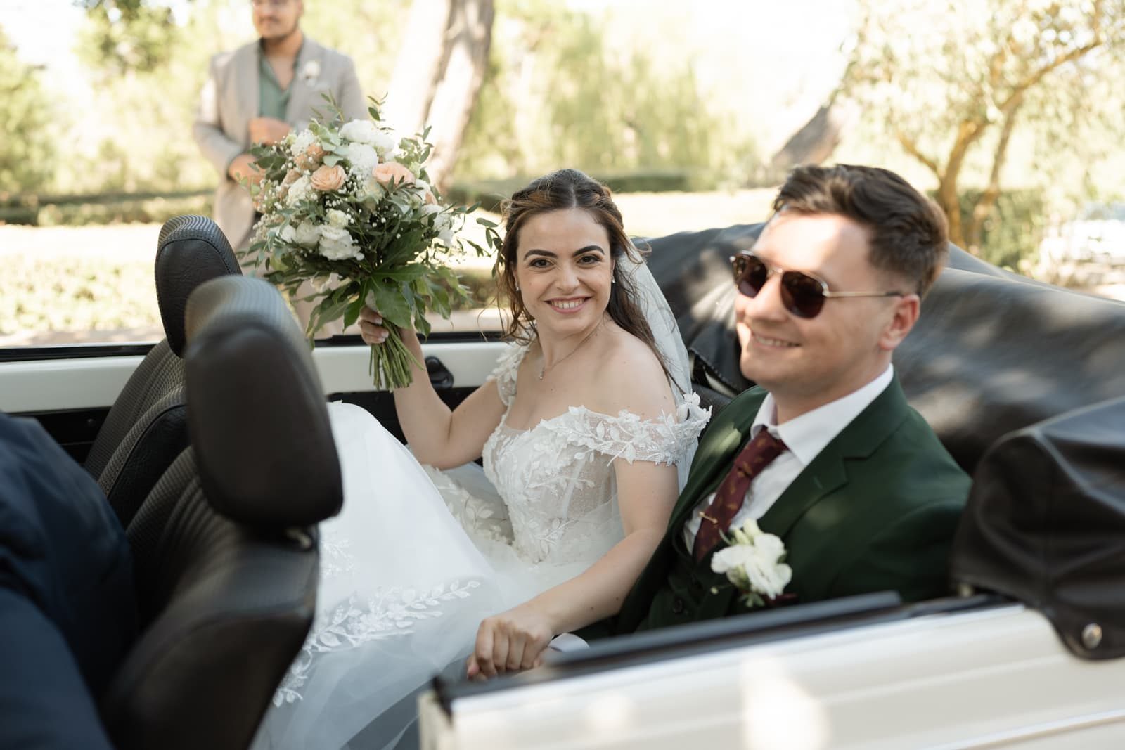 Bride holding her bouquet in the wedding car