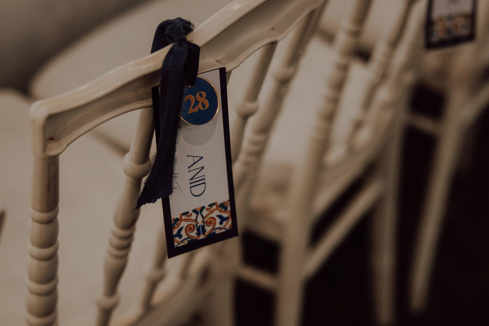 A hand-lettered place card in blue and gold
