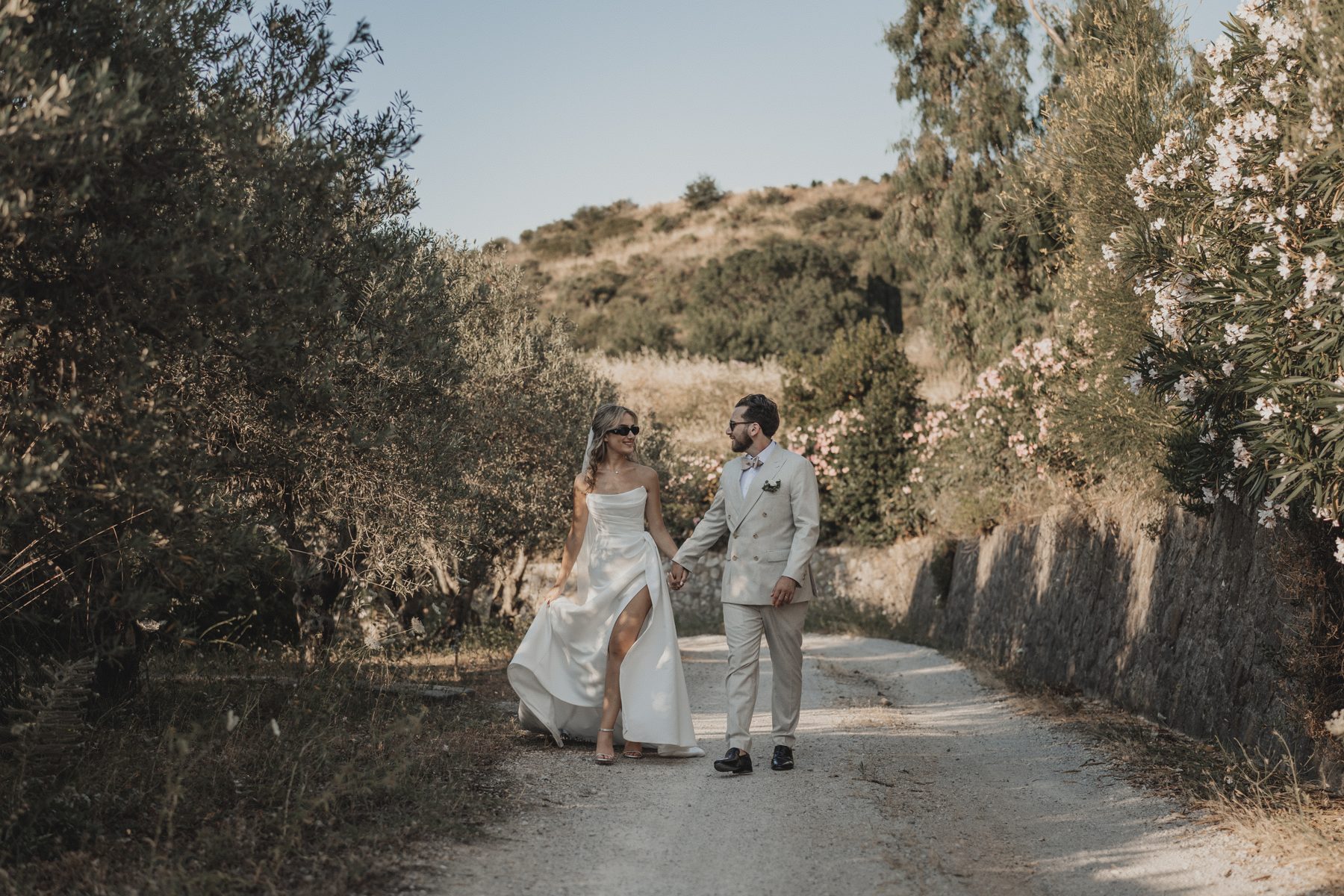 The couple walking a country lane between olive trees and oleander