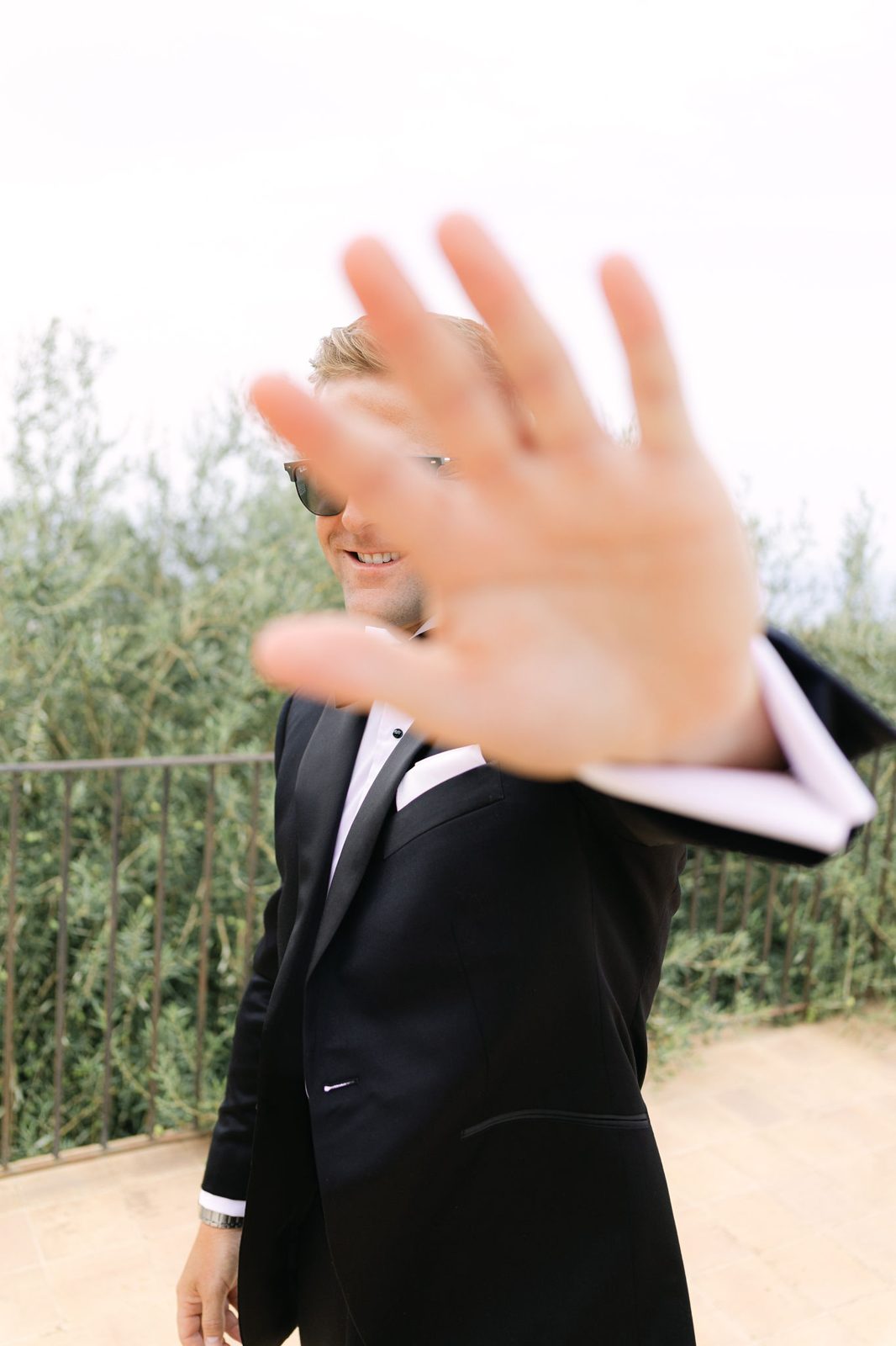 The groom, a playful hand to the camera