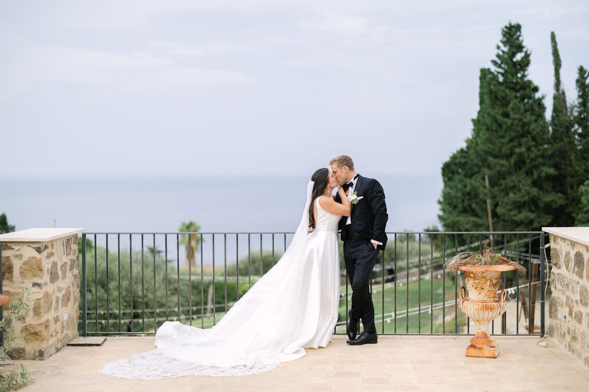 A stolen kiss on the villa terrace, the sea beyond