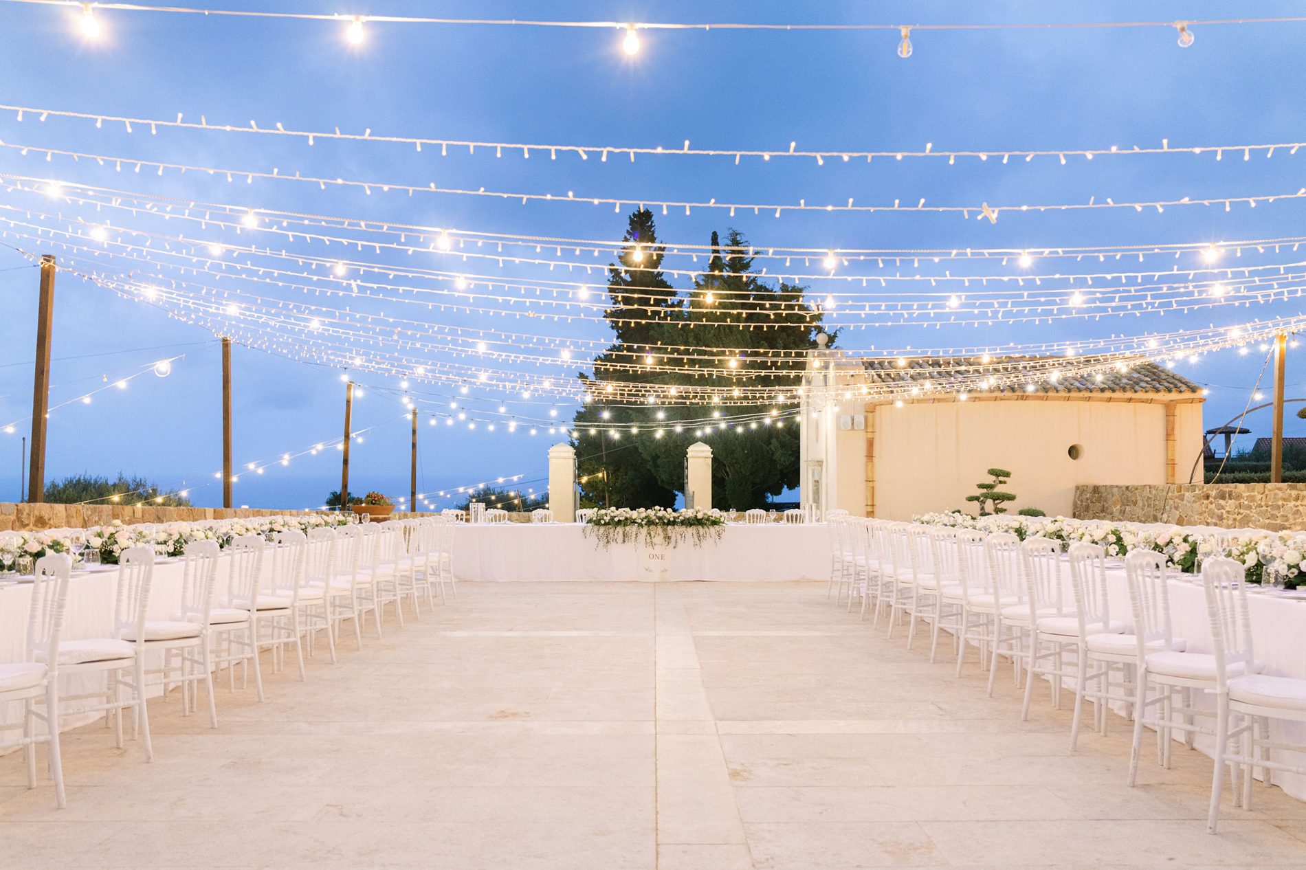 The reception at blue hour, under a canopy of string lights
